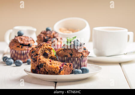 Muffin alla carota con blueberrie bianco su sfondo di legno Foto Stock