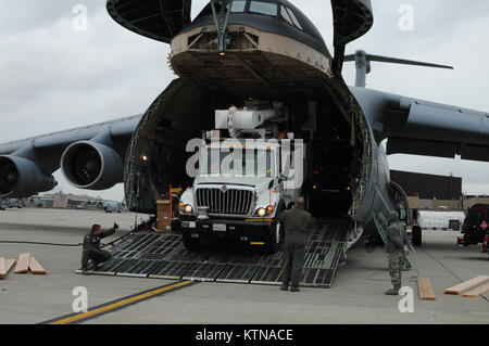 STEWART ANGB NEWBURGH, N.Y. --Travis loadmasters e 105antenna LRS Port aria guardie off-caricamento di un veicolo di supporto appartenente al Southern California Edison utility company da un C-5B Galaxy. I veicoli di scena presso il 105° Airlift Wing si muoverà fuori per sostenere gli sforzi per ripristinare la potenza e fornire aiuti umanitari alla regione colpita. Parte della difesa USNORTHCOM sostegno delle Autorità civili missione dirige il comando per pianificare e anticipare le azioni che si possono avere bisogno di prendere per sostenere le autorità civili. USNORTHCOM svolge un ruolo importante nella risposta di emergenza; tuttavia, tutte le Foto Stock