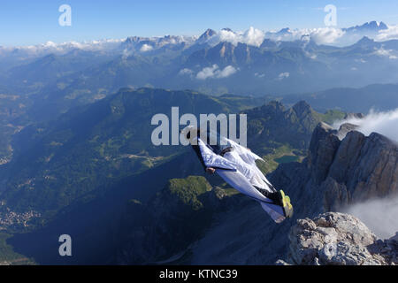 Questo Wingsuit ponticello di base appena scavalcato il ciglio della scogliera e brave diving giù nell'incerto. Ben presto egli deve aprire il suo paracadute da salvare. Foto Stock