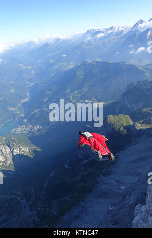 Questo Wingsuit ponticello di base appena scavalcato il ciglio della scogliera e brave diving giù nell'incerto. Ben presto egli deve aprire il suo paracadute da salvare. Foto Stock