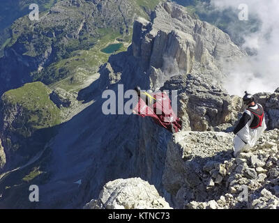 Questo Wingsuit ponticello di base appena scavalcato il ciglio della scogliera e brave diving giù nell'incerto. Ben presto egli deve aprire il suo paracadute da salvare. Foto Stock