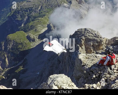 Questo Wingsuit ponticello di base appena scavalcato il ciglio della scogliera e brave diving giù nell'incerto. Ben presto egli deve aprire il suo paracadute da salvare. Foto Stock