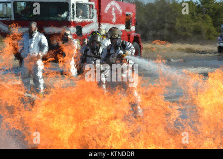 WESTHAMPTON BEACH, NY - Air Force Vigili del Fuoco con la 106ª Rescue treno ala civile con i vigili del fuoco per rimuovere le vittime simulato da un ardente aeromobili a FS Gabreski Air National Guard Base in Westhampton, New Ork il 2 aprile 2013. Il aviatori sono assegnati alla 106ª Ingegneria Civile Squadron. Kellogg University hanno fornito la simulazione di aerei che bruciò il propano per un valore stimato di 1.200 gradi. Foto Stock