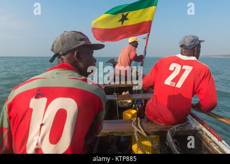 I pescatori nella loro barca open andare a pesca nelle prime ore del mattino. Essi racchetta da net a net per recuperare le loro catture, Kokrobite, maggiore Regione di Accra, Ghana Foto Stock