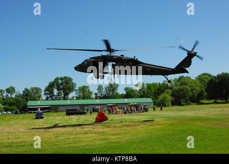 Intorno al lago, N.Y. -- A New York Army National Guard UH-60 Blackhawk basato a Latham decolla dal Lago Rotondo airport qui di condurre secchio di acqua di formazione presso il Lago Rotondo Municipal Airport, 4 giugno. Il New York esercito Guardia Nazionale e la polizia di stato addestrato i loro equipaggi in elicottero per preparare per la lotta contro gli incendi selvatico allo stesso tempo e luogo. In aggiunta, nello Stato di New York Dipartimento di Conservazione Ambientale Forest Rangers sono stati sul sito per osservare e aiutare gli equipaggi manuever per acqua goccia punti, proprio come farebbero durante un incendio nella foresta. Entrambi i velivoli usano un sistema di distribuzione noto come Bambi Buc Foto Stock