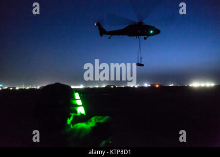 Un UH-60 Black Hawk gestiti da società A, 3° Battaglione, 142th elicottero d'assalto battaglione, vola fuori dopo il prelevamento di un 4.000 lb. peso durante la notte imbracatura le operazioni di carico con la 642nd aviazione battaglione di supporto su Giugno 5, 2014, a Camp Buehring in Kuwait. Il 642nd e 142ND, entrambi sotto la XLII Combattere la Brigata Aerea, New York Army National Guard, vengono distribuiti al Kuwait a sostegno dell'Operazione Enduring Freedom. (N.Y. Esercito nazionale Guard foto di Sgt. Harley Jelis/rilasciato) Foto Stock