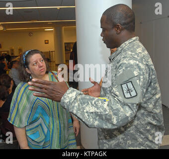 NEW YORK CITY -- New York Army National Guard Capt. Glenford Rose (destra) parla con Nadia Shaulova (sinistra) durante una sessione del governatore di New York Andrew Cuomo's cittadino Preparazione Corps Programma di formazione presso le Nazioni Unite Scuola internazionale qui in agosto 12, 2014. New York La Guardia Nazionale truppe diede la catastrofe e la formazione di emergenza a circa 300 persone che hanno partecipato all'evento. Il programma è concepito per fornire ai cittadini le conoscenze e gli strumenti per preparare per le emergenze e calamità, rispondere di conseguenza, e recuperare il più rapidamente possibile al pre-condizioni di emergenza. New York La Guardia Nazionale tr Foto Stock