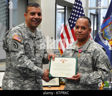 LATHAM -- New York Army National Guard Col. John Andonie awards Lt. Col. Emilio Pennes un meritorio medaglia di servizio durante la sua cerimonia di pensionamento qui, nov. 8. Pennes si ritira con trenta anni di servizio. (US Army National Guard foto di Sgt. Principali Lombardo Corine/RILASCIATO) Foto Stock