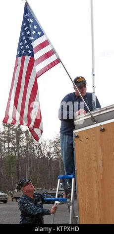 LEEDS, N.Y. -- Chief Warrant Officer 2 Arte Nolan del New York Stato milizia navale (NYSNM) detiene una scaletta per New York Guard Sgt. Il Mag. Contrassegnare Copeletti del nuovo come egli controlla una antenna sul NYSNM recentemente aggiornato il comando mobile post a New York Army National Guard armory qui il 10 marzo. Membri della milizia, New York i membri di guardia e New York Army National Guard per esperti di comunicazione anche testato il posto di comando è installato di recente le radio e computerizzato di identificazione automatica del sistema qui il 10 marzo e 16. Il sistema visualizza in tempo reale le informazioni sul traffico in barca in qualunque New York Foto Stock