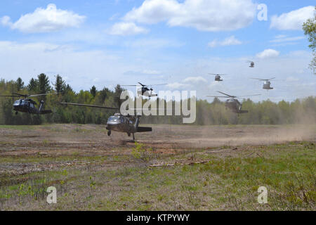 UH-60 Black Hawk elicotteri da B Company, 3° Battaglione, 142th elicottero d'assalto battaglione, 42nd combattere la Brigata Aerea volare in una zona di atterraggio a Fort Drum, New York con i soldati del secondo battaglione, 108th Fanteria, 27 della brigata di fanteria come parte di un assalto dell'aria esercizio maggio, 18, 2016. (U.S. Esercito nazionale Guard foto di Spc. Sarah Ronsani/ rilasciato) Foto Stock