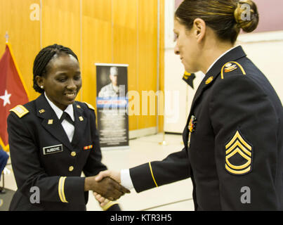 2 Lt. Olushola O. Ajiboye, un recentemente commissionato ufficiale della New York Army National Guard, riceve il suo primo saluto da Sgt. 1. Classe Melissa Guckian, durante il secondo battaglione, 106ª Reggimento regionale istituto di formazione, candidato ufficiale della scuola di 61o la messa in funzione della classe di graduazione, Agosto 20, 2016. (U.S. Esercito nazionale Guard foto di Capt. Amy Hanna) Foto Stock