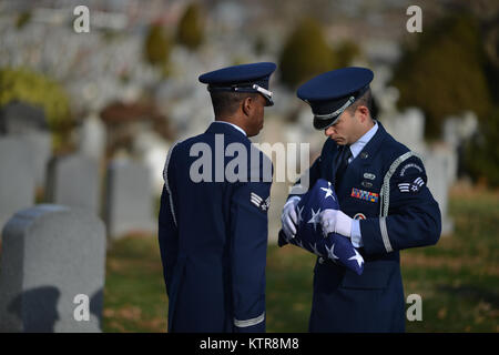 QUEENS, NY - Senior aviatori Corey Smith e Dominic Surinaga eseguire una piegatura di bandiera cerimonia al funerale per Master Sgt. Timotyh David Ryan al Cimitero di St. John nel Queens, a New York il 16 dicembre 2016. In aggiunta ad altri doveri cerimoniali, membri della 106ª Guardia d'onore sono spesso chiamati a fornire gli onori militari per Veteran's funerali. (US Air National Guard / Staff Sgt. Christopher S. Muncy / rilasciato) Foto Stock