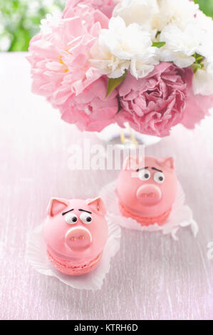 Torte di rosa a forma di suini con un bouquet di peonie in vacanza. Copiare il posto. Il telaio verticale. Foto Stock