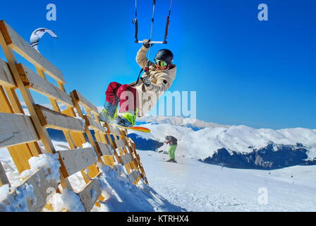 Atleta snowboarder facendo snowkiting sulla neve in montagna Foto Stock