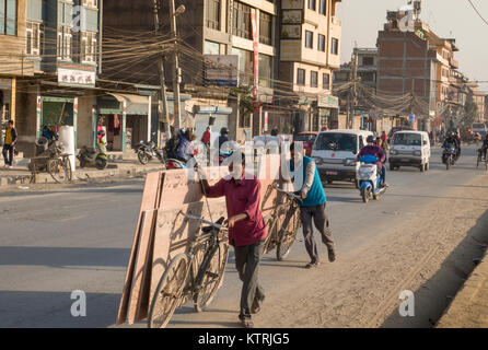 Gli uomini utilizzando le biciclette per il trasporto dei fogli di legno compensato in Kathmandu, Nepal Foto Stock