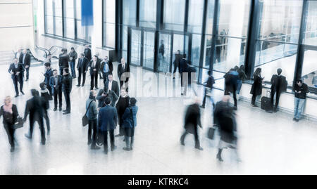 La gente di affari precipitando in un moderno commercio equo lobby Foto Stock