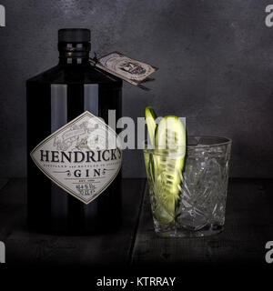 SWINDON, Regno Unito - 27 dicembre 2017: 70 cl bottiglia di Hendricks gin distillato con un bicchiere e il cetriolo al buio su un sfondo rustico Foto Stock