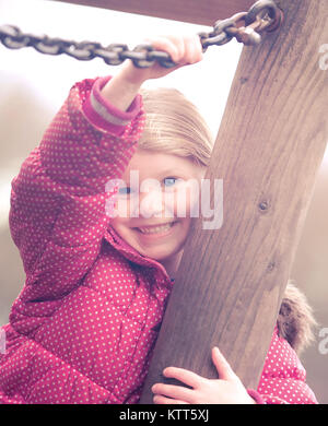 Ragazza che gioca in un parco giochi Foto Stock