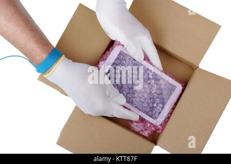 Il tecnico in i guanti antistatici prende una compressa di parte di ricambio dalla confezione industriale. Isolato su bianco top view studio concept Foto Stock