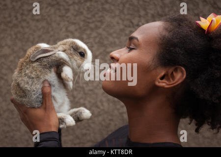 Idealista giovani afro american donna fantasticando con Natale bunny coniglio nelle sue mani Foto Stock