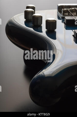 Un blu cinque string bass guitar è strategicamente posizionato nel telaio con un nero lo sfondo di legno. Questa è un'immagine più scura che sottolinea la sl Foto Stock
