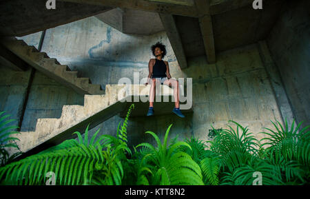 Il Melanesian pacific islander atleta ragazza con forti braccia dopo la seduta di allenamento a scala in edificio abbandonato Foto Stock