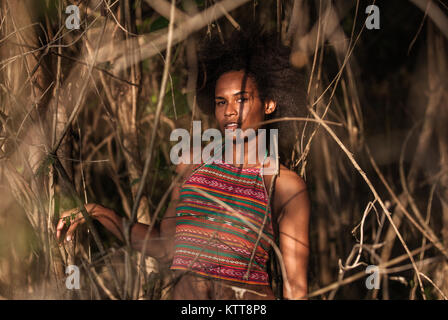 Il Melanesian pacific islander atleta ragazza con i capelli afro sytile nella giungla, profilo a metà Foto Stock