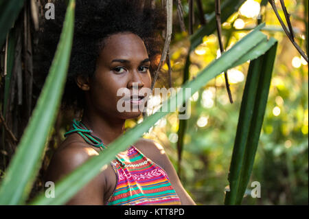 Il Melanesian pacific islander atleta ragazza con i capelli afro sytile nella giungla, profilo a metà Foto Stock