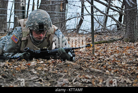 Spc. Kyle A. Lentz della sede centrale e sede azienda 37th della brigata di fanteria combattere crawl del Team sotto il filo spinato nel campo Ravenna militare congiunta del centro di formazione, aprile 6,2011 premobilization durante la formazione. La Sommerset, Ohio, nativo, lungo con 3.600 altri soldati del 37th, è programmato per distribuire in Afghanistan nell'autunno 2011 per una distribuzione yearlong a sostegno dell'Operazione Enduring Freedom. (Ohio Guardia Nazionale foto di PFC. Andrew Kuhn) (rilasciato) Foto Stock