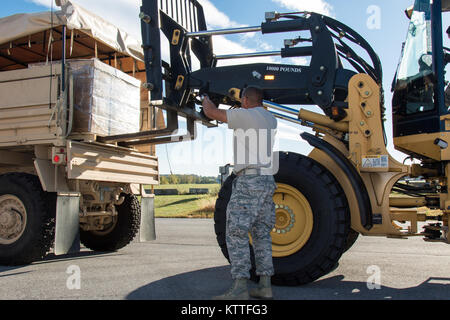 New York La Guardia Nazionale soldati con la 53a comando di truppa e Airman con 105Airlift Wing scaricare 540 casi di pasti pronti a mangiare e 117 culle su Stewart Air Base, Newburgh, N.Y., Sett. 29, 2017. Il cibo e i materiali di consumo sono in fase di pre-posizionato a Stewart Air Base per essere volato a Puerto Rico e Stati Uniti Isole Vergini come parte di New York con il supporto continui sforzi di ripristino dopo gli uragani di Irma e Maria. (U.S. Esercito nazionale Guard photo by Staff Sgt. Michael Davis) Foto Stock