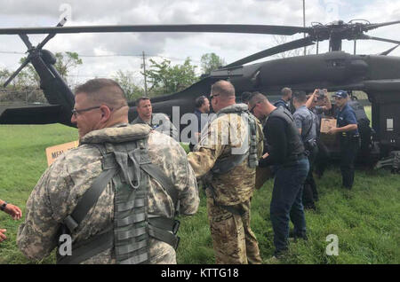 Lo stato di New York di poliziotti e soldati assegnati al New York esercito Guardia Nazionale il 3° Battaglione, 142th Aviation scaricare la fornitura di aiuti in Bayamon, Puerto Rico ad Ottobre 9, 2017.Il battaglione dispiegato 60 soldati e 4 UH-60 elicotteri a Puerto Rico per assistere nel post- uragano Maria le operazioni di soccorso. Foto Stock