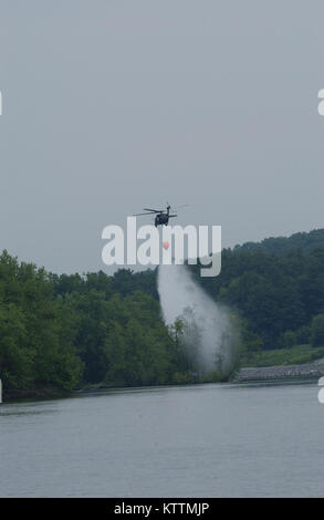 A New York Army National Guard UH-60 Blackhawk elicottero solleva un Bambi benna riempita con 660 galloni di acqua al di fuori del Fiume Hudson durante il fuoco della benna sulla formazione Giugno 28. Foto Stock