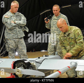 Col. James Perry, comandante di brigata per la trentasettesima della brigata di fanteria combattere Team osserva Sgt. Sean Clark, drone maintainer assegnato alla sede centrale e sede società, 37th IBCT, come Chief Warrant Officer 2 James P. Huck IV, operatore drone anche assegnati alla HHC 37th IBCT, spiega l'ombra 200 UAV di capacità prima di una dimostrazione di volo a Camp Shelby forze congiunte Training Center, Miss., nov. 5, 2011. L'UAV sarà utilizzato dal 37th IBCT durante la loro prossima distribuzione per l'Afghanistan a sostegno dell'Operazione Enduring Freedom. (37Th IBCT foto di Sgt. Kimberly agnello) (R Foto Stock