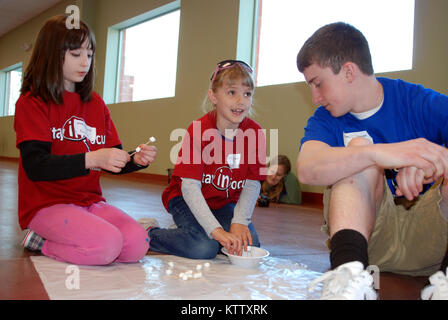 Matt Murray, una vita scout da Brunswick, aiuta a 9 anno di età, Kristen Rossler di Scotia e Katie Hibbard di Binghamton costruire un progetto durante il 2012 NY la Guardia Nazionale Famiglia e VolunteerTraining Workshop presso il bordo in Halfmoon, 14 apr. Murray si offrì come una gioventù mentor per il giorno la focalizzazione sulle attività di team building. Foto Stock