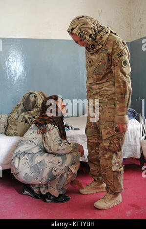 Il personale Sgt. Desiree Barrett, operazioni noncommissioned officer e femmina team engagment stati assegnati a società di sede, 37th della brigata di fanteria combattere la squadra, è cercato da una femmina di frontiera afgana soldato della polizia nel corso di una shura in Haritan, Balkh Provincia, Afghanistan, 21 aprile 2012. La trentasettesima IBCT è distribuito in Afghanistan a sostegno della Forza internazionale di assistenza alla sicurezza al fine di costruire Polizia nazionale afgana di capacità. (37Th IBCT foto di Sgt. Kimberly agnello) (rilasciato) Foto Stock