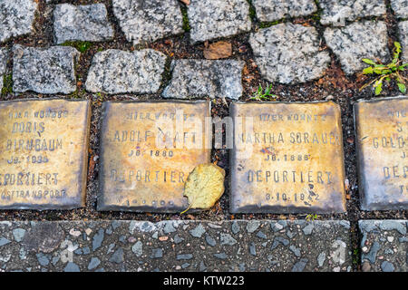 Stolpersteine (cippi) in una strada a Berlino per commemorare le vittime dei campi di sterminio nazisti - principalmente ebrei - Berlino, Germania Foto Stock