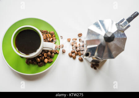 Alta angolazione di un italiano di Moka pot (caffè) e un verde tazzina con chicchi di caffè su sfondo bianco Foto Stock