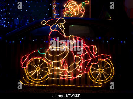 Babbo Natale a cavallo di una moto luci di natale su una casa nel Cotswolds, Worcestershire, Inghilterra Foto Stock