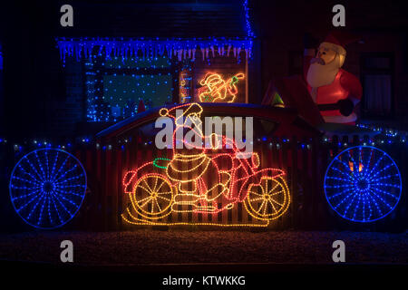 Babbo Natale a cavallo di una moto luci di natale su una casa nel Cotswolds, Worcestershire, Inghilterra Foto Stock