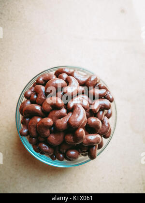 Ricoperta di cioccolato in biscotto a forma di fagiolo su sfondo di legno. Foto Stock