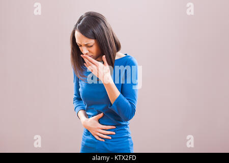 Ritratto di giovane donna che sta avendo il dolore nel suo stomaco. Foto Stock