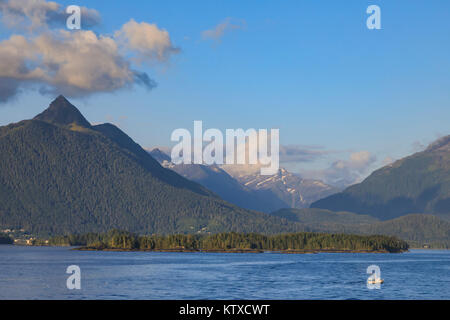 La pesca commerciale nave foresta montagne innevate, rare sole serale, Sitka Sound off Baranof Island, Sitka, Alaska, Stati Uniti d'America, Foto Stock