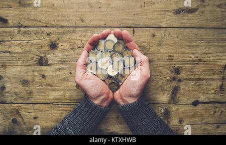 Man mano tenendo un mucchio di monete in euro banner sfondo, vista dall'alto, con spazio di copia Foto Stock