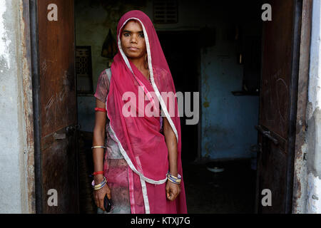Ritratto di giovane donna indiana indossando sari e un velo su i suoi capelli in casa sua, villaggio nei pressi di Pushkar, Rajasthan, India. Foto Stock