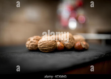 Miscelate insieme i dadi nel loro guscio comprendente le noci, le nocciole, le mandorle e le noci pecan con una profondità di campo ridotta Foto Stock