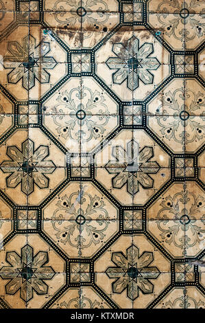 Weathered, azulejo portoghese le piastrelle di ceramica con un disegno floreale che ornano le pareti esterne di un edificio a Lisbona, Portogallo. Foto Stock
