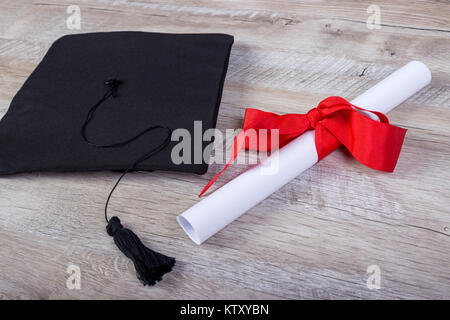 Tappo di graduazione, cappello con grado di carta sul tavolo in legno concetto di graduazione. Foto Stock