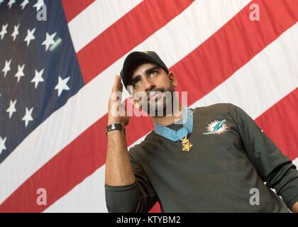 Stati Uniti Army Medal of Honor destinatario Florent Flo Groberg saluta U.S. I marinai della marina militare a bordo della U.S. Nimitz Navy-class portaerei USS Theodore Roosevelt durante l'OSU Tour Vacanza Dicembre 23, 2017 nel Golfo Arabico. Foto Stock