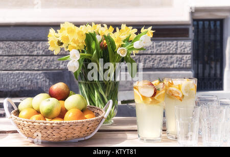 Staffa di frutta e i mazzi di fiori di primavera su un tavolo all'aperto Foto Stock