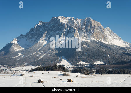 Paesaggio innevato con le montagne del Wetterstein, il Monte Zugspitze e la pianura Ehrwalder nel sole del pomeriggio, Tirolo, Austria Foto Stock